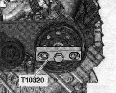 Свалете ролката на ангренажния ремък с помощта на скобата T10320. Свалете левия капак на…