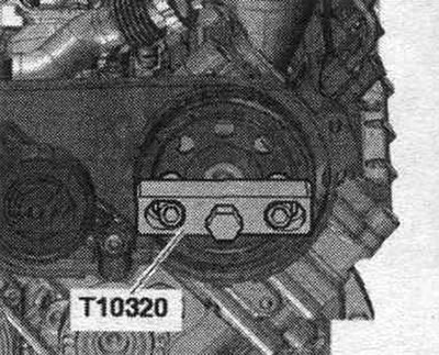 Свалете ролката на ангренажния ремък с помощта на скобата T10320. Ролката на ангренажния ремък…