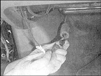 8. Unscrew the two mounting bolts (indicated by arrows) and remove the fuse box.