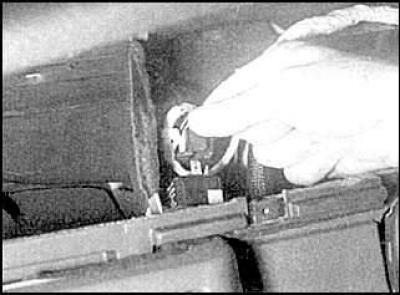 8. Unscrew the two mounting bolts (indicated by arrows) and remove the fuse box.