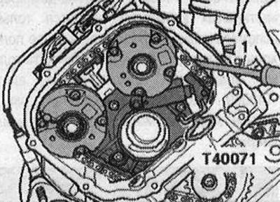 Фигурата показва лявата цилиндрова глава. Преместете плъзгача на левия обтегач на веригата на…