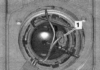 Zdejmij 1/3 tylnego siedzenia po prawej stronie. Odkręć śruby ze strzałkami i zdejmij pokrywę «1»…